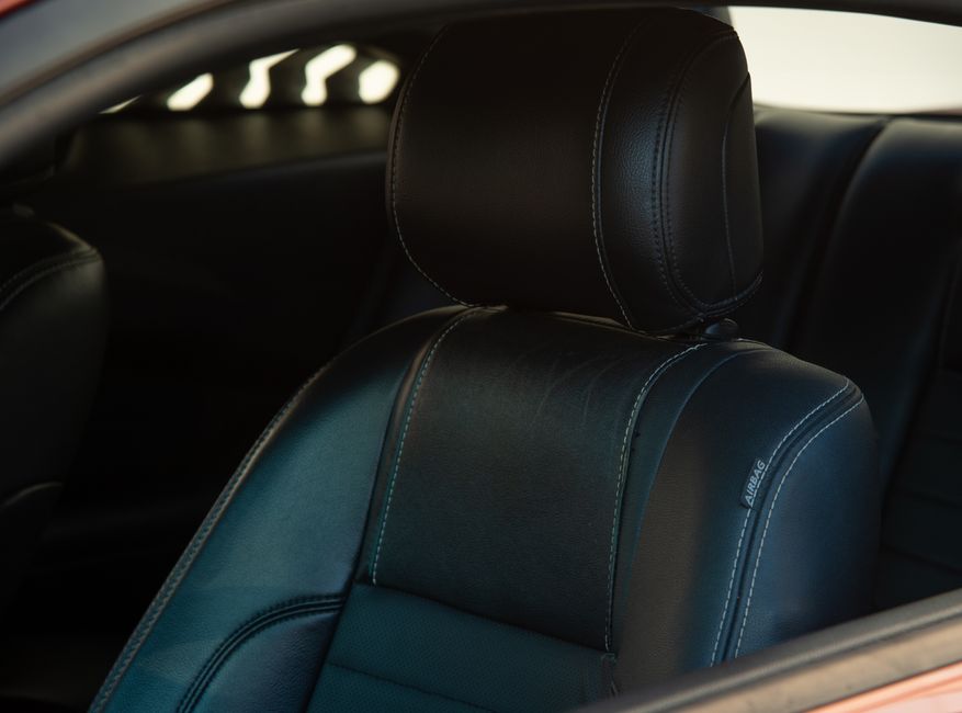 Close-up of a luxury car's black leather seat, showcasing premium interior design.
