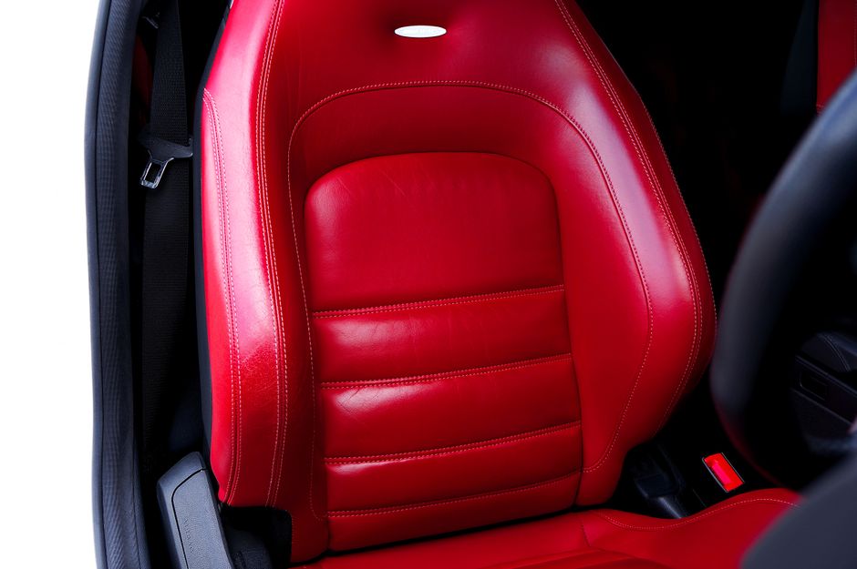 High-quality close-up of a vibrant red leather car seat, showcasing luxury and comfort.